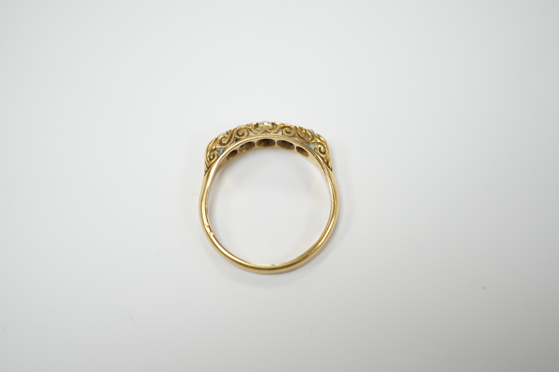 An Edwardian 18ct gold and graduated five stone diamond set half hoop ring. size R, gross weight 4.4 grams.